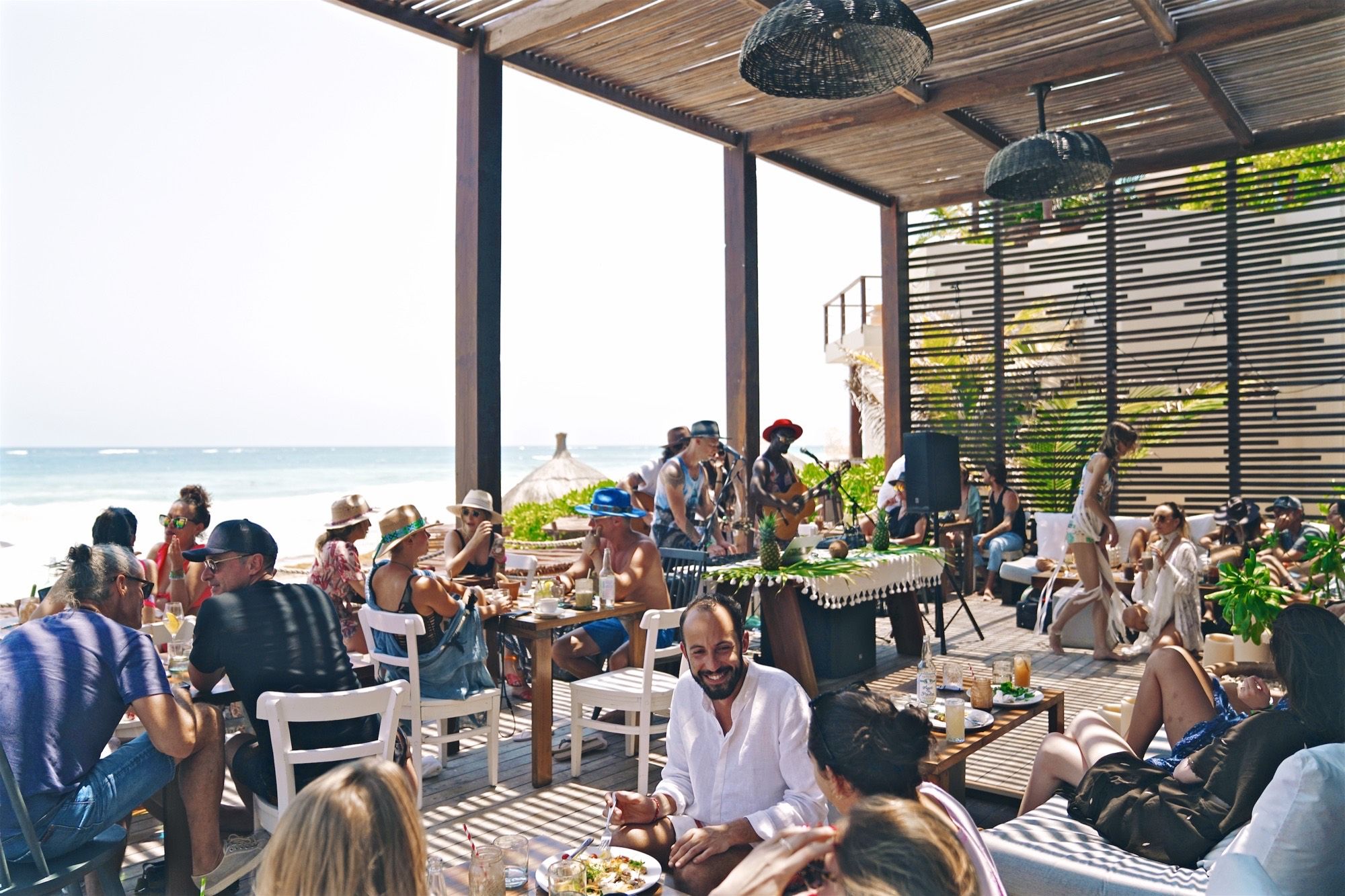 The deck at the beach, full, with music, the sea beyond